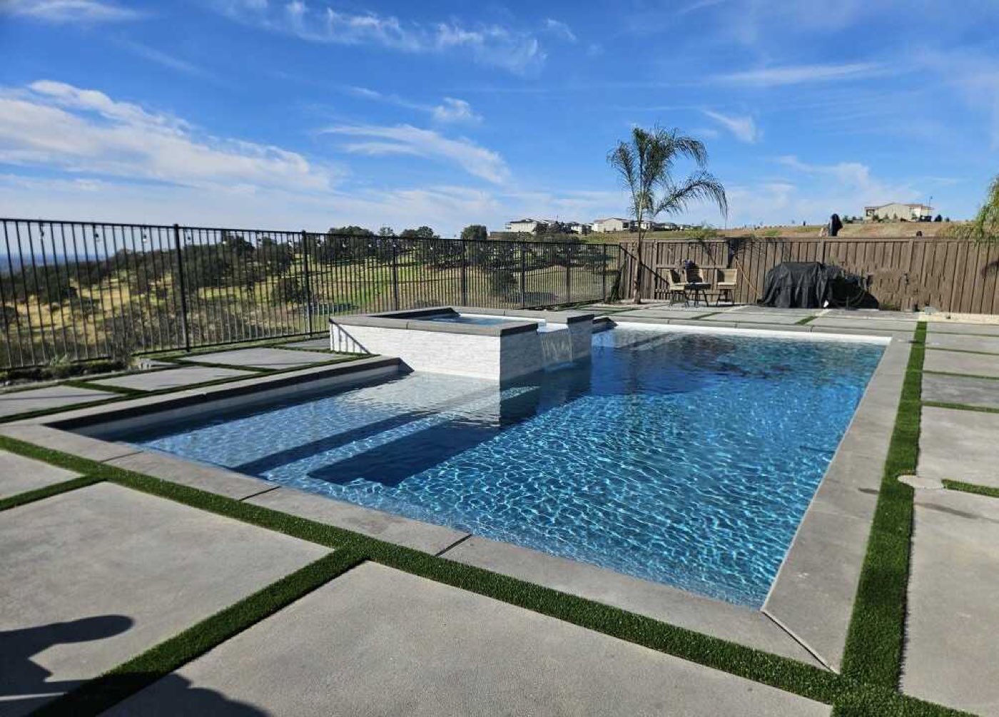 Rectangular pool with raised spa and sheer-descent water features