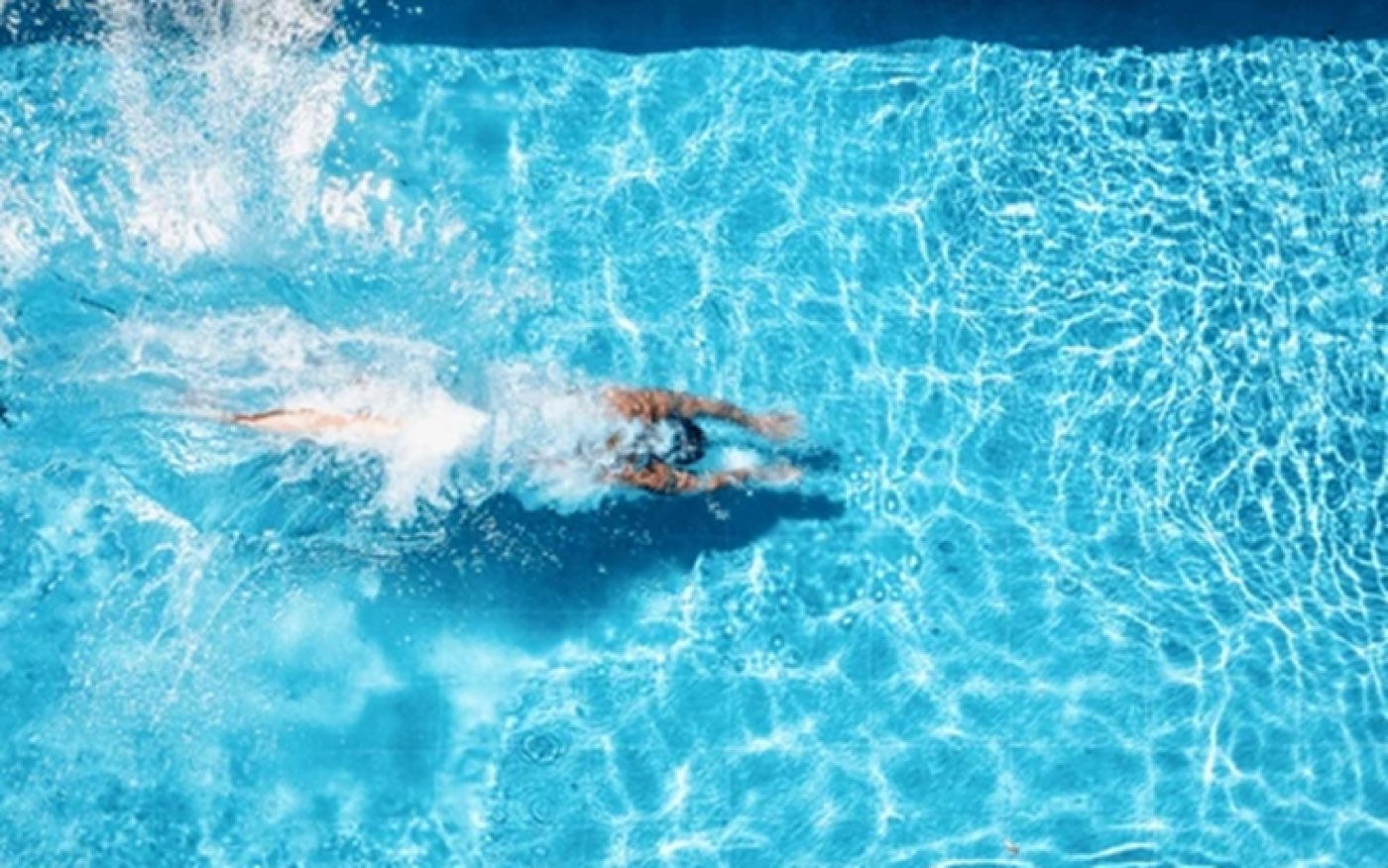Aerial view of a swimmer jumping into a pool
