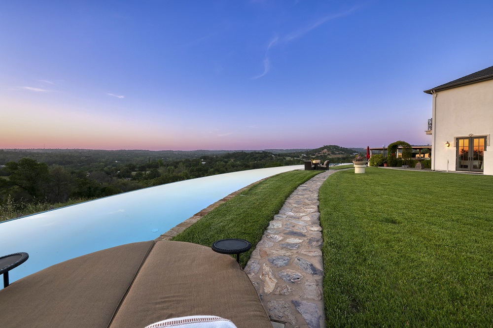 Long curved infinity edge pool at sunset.