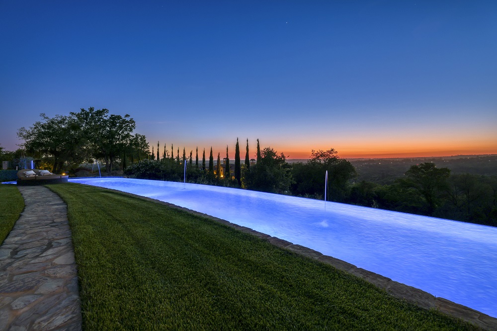 Large curved infinity edge pool with laminars in the evening.