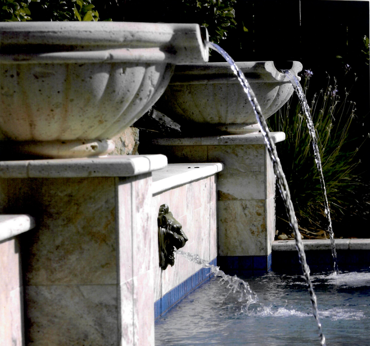 Pool with water features from bowls on top of columns and a lion head all spilling into the pool