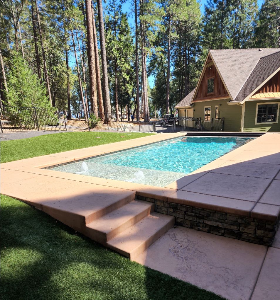 Raised rectangular shaped pool with ledgerstone and large Cabo shelf with two bubblers.