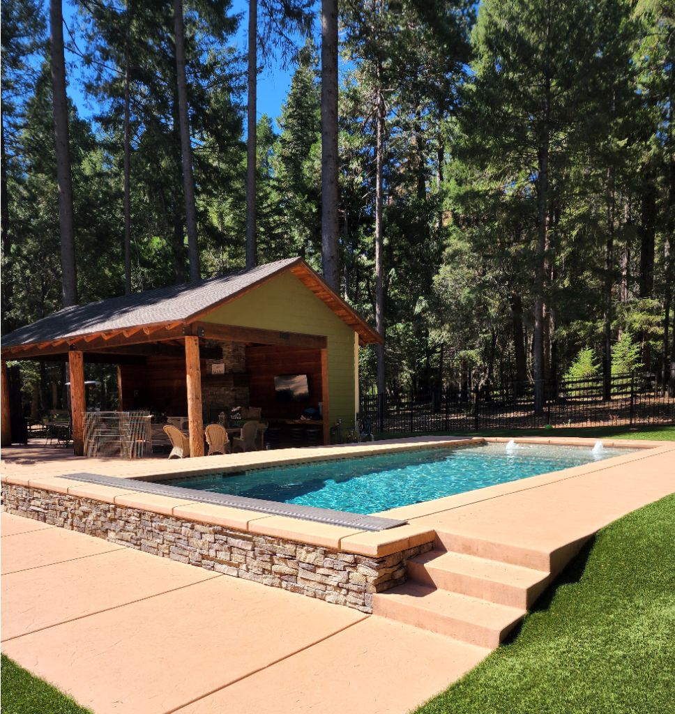 Raised rectangular shaped pool with ledgerstone, an automatic pool cover and large Cabo shelf with two bubblers.