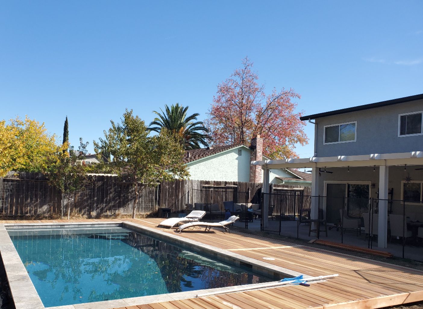 Rectangular shaped pool approx. 400 square feet with travetine stone coping and wood decking.