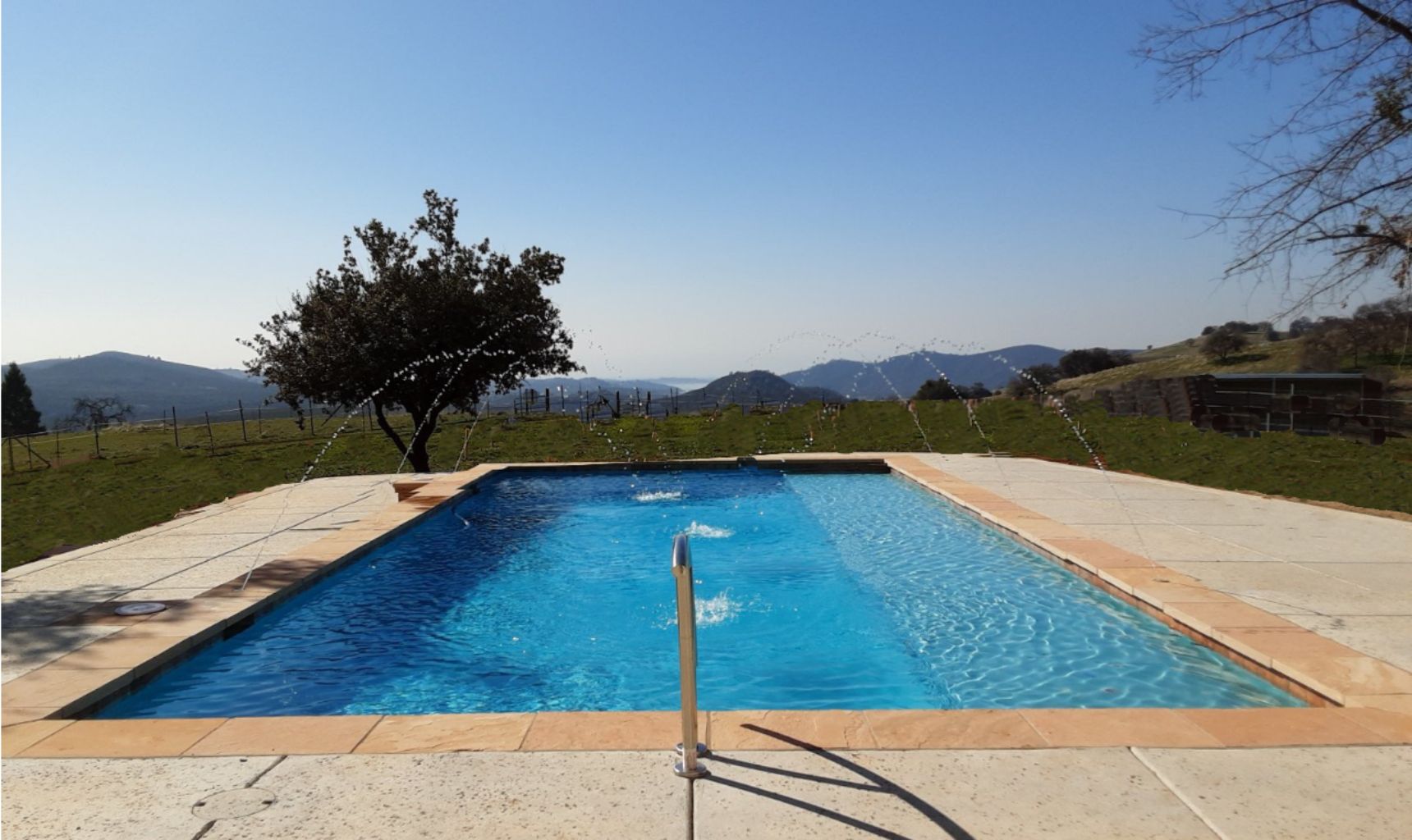 Partially raised rectangular shaped pool approx. 38' x 16' (685 square feet) with ledgerstone and deck jets.