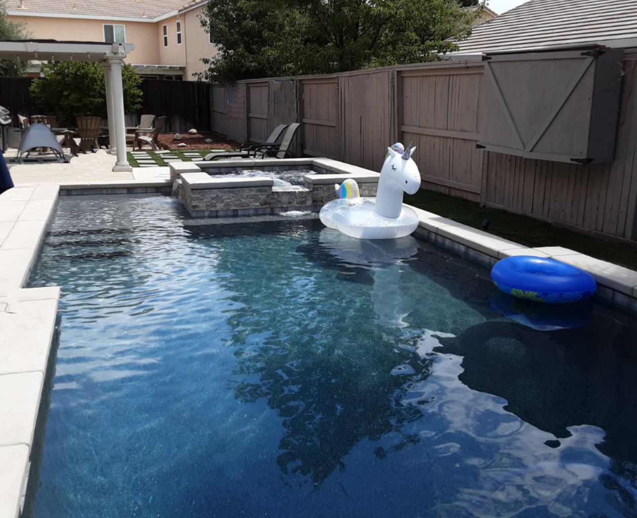 Rectangular shaped pool approx. 400 square feet with raised spa with two spillovers and large unicorn pool float.