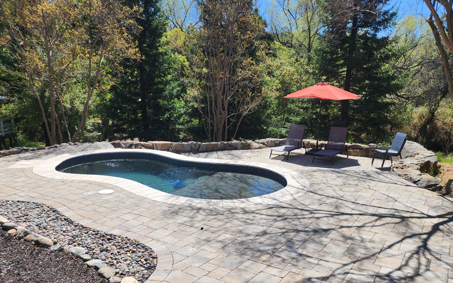 Small freeform pool with Cabo shelf, stone coping and pavers.