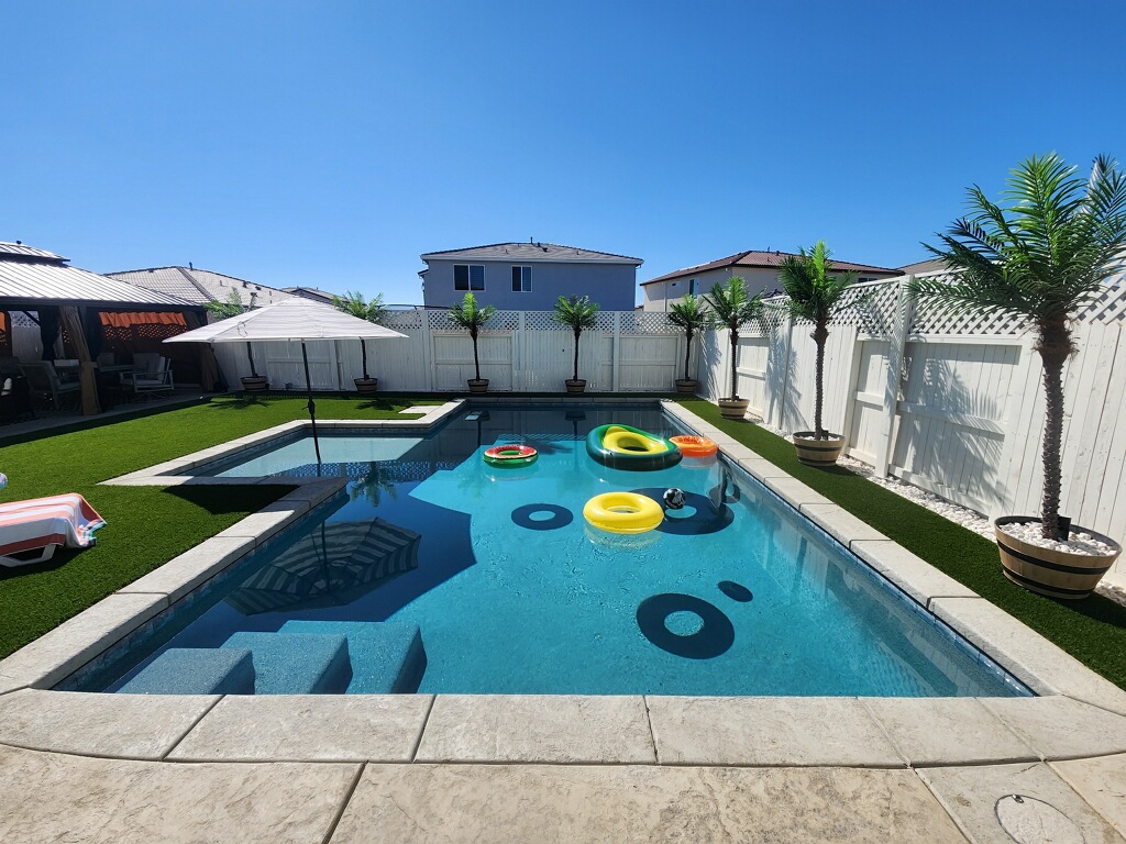 Rectangular shaped pool with bumped out Cabo shelf and pool ring floats