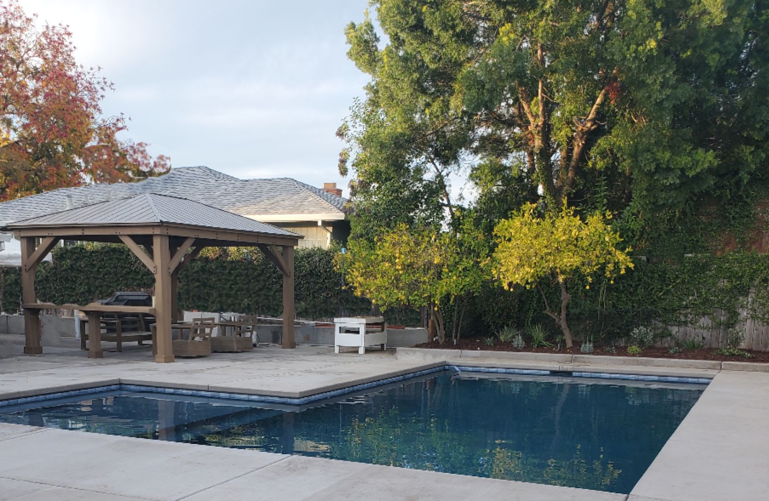 Rectangular shaped pool with larged bumped out Cabo shelf and concrete decking and coverred loggia.