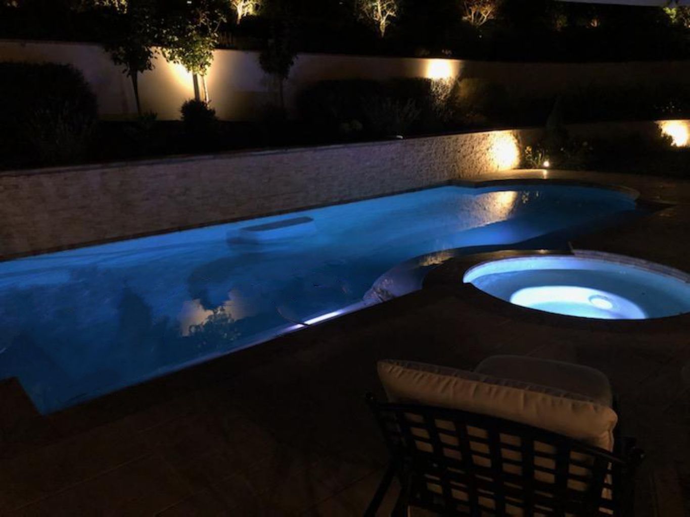 Grecian shaped pool and spa in evening.