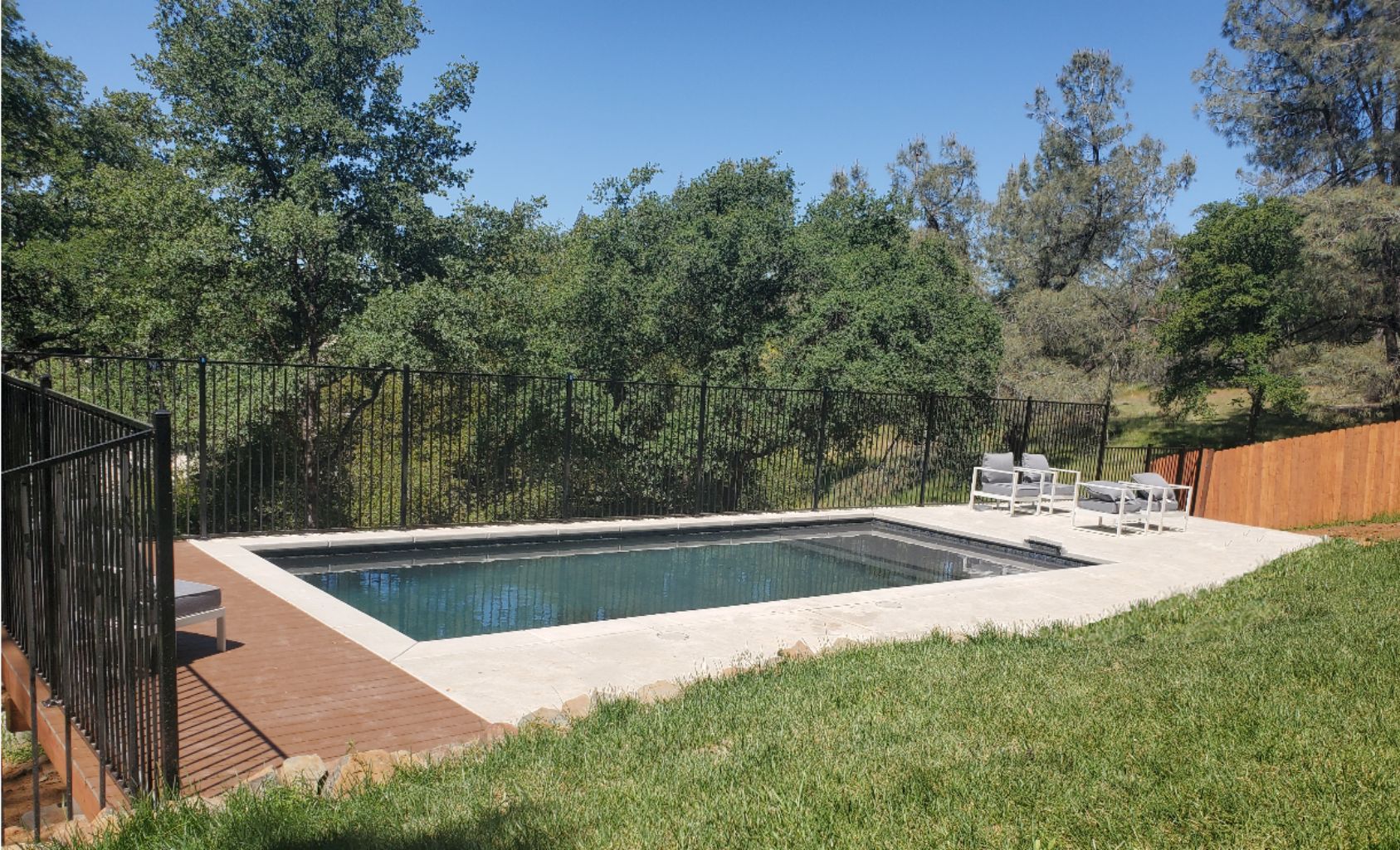 Rectangular shaped pool with views of oak trees on sloped lot in Northern California.