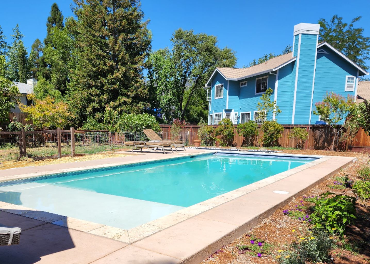 Rectangular shaped pool with an automatic pool cover, stone coping and colored concrete decking.