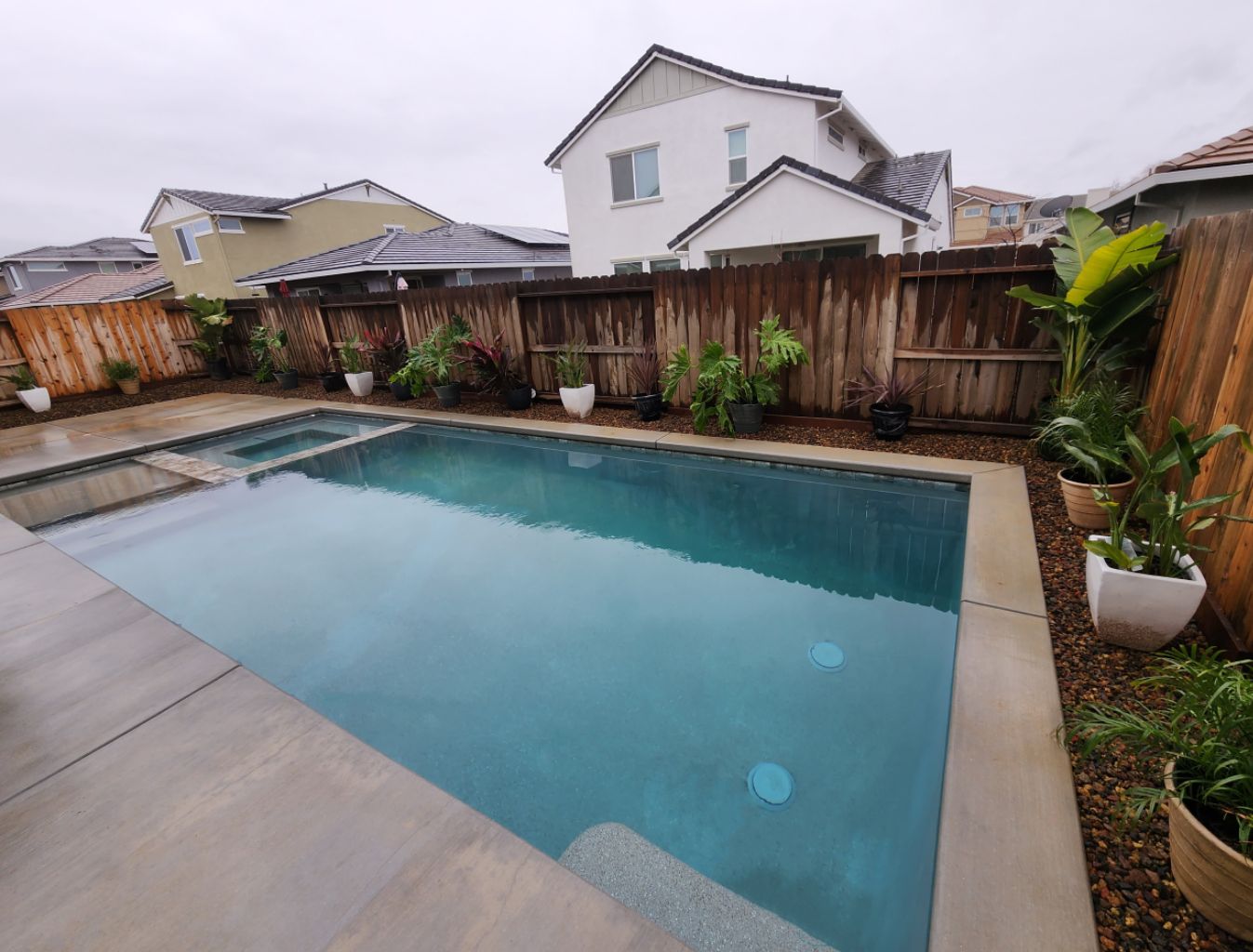 Rectangular shaped pool with a Cabo shelf and a spa and concrete decking and coping.