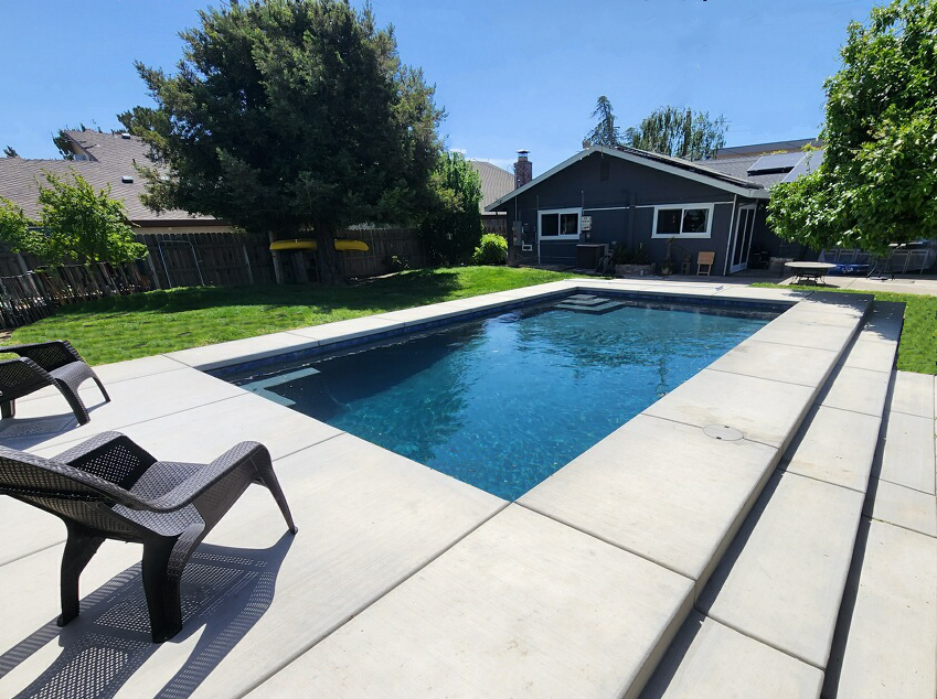 Rectangular shaped pool with concrete decking and long steps.