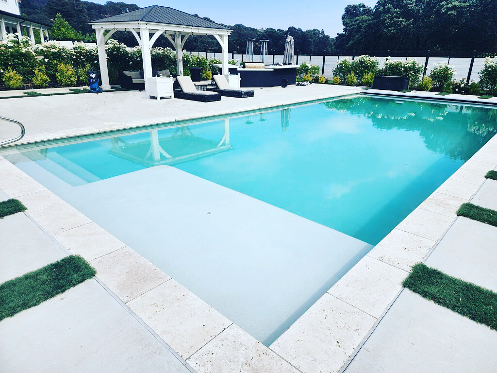Pool with Cabo shelf and white plaster and a gazebo in the background