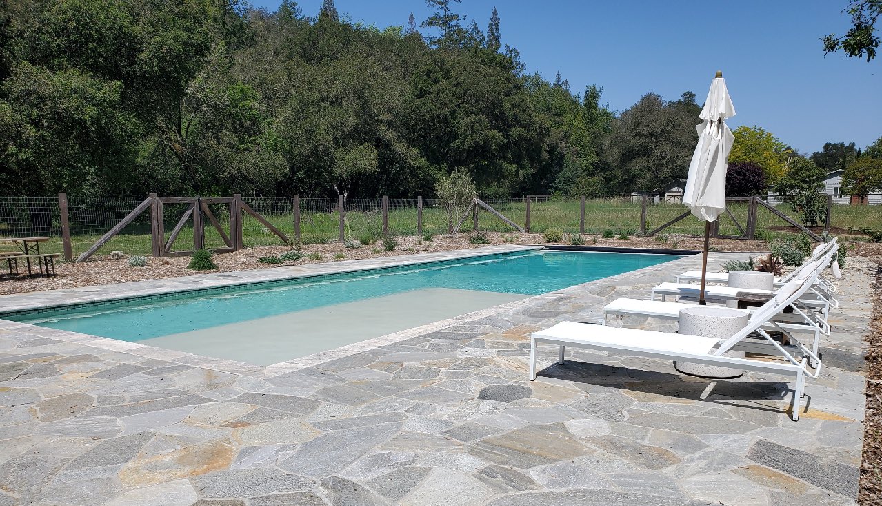 Pool with patio loungers at a Cookie Cutter Pools project