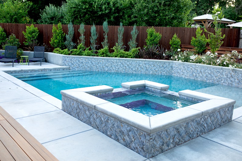 Raised spa with sheer descent into rectangular pool with Cabo shelf