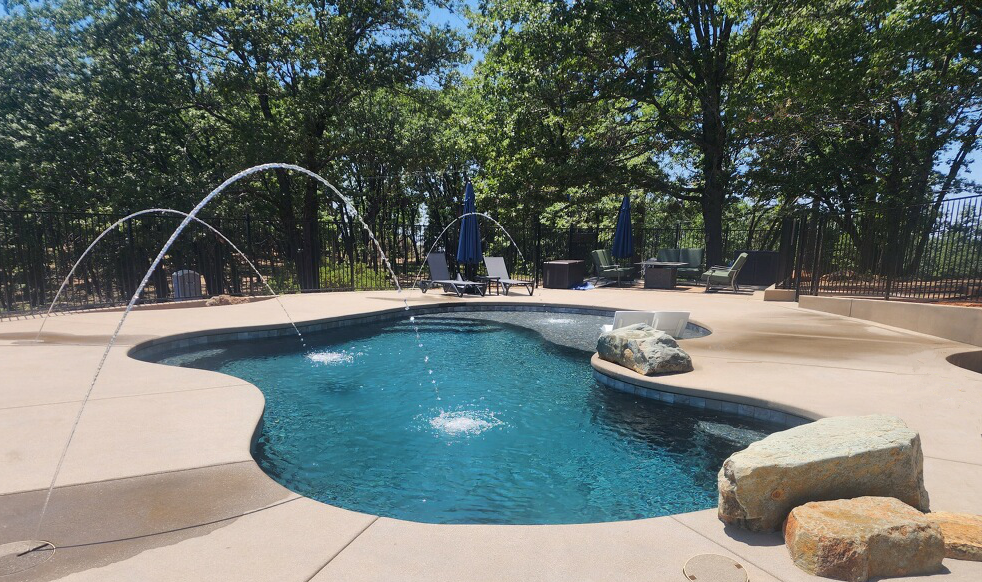 Freeform shaped pool with colored LED laminars and jumping rocks in Nevada City