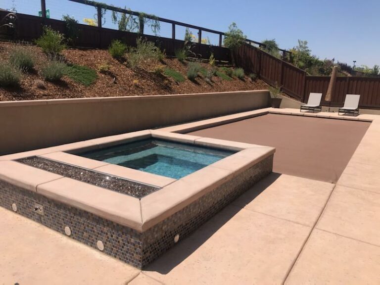 Raised spa with automatic pool cover and raised retaining wall